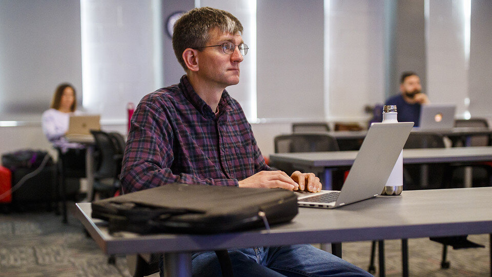 Chad Brassil working on a computer while participating in a workshop